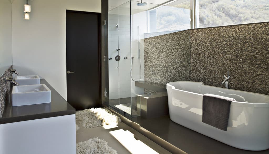 A modern bathroom with stone countertops and a stone feature wall